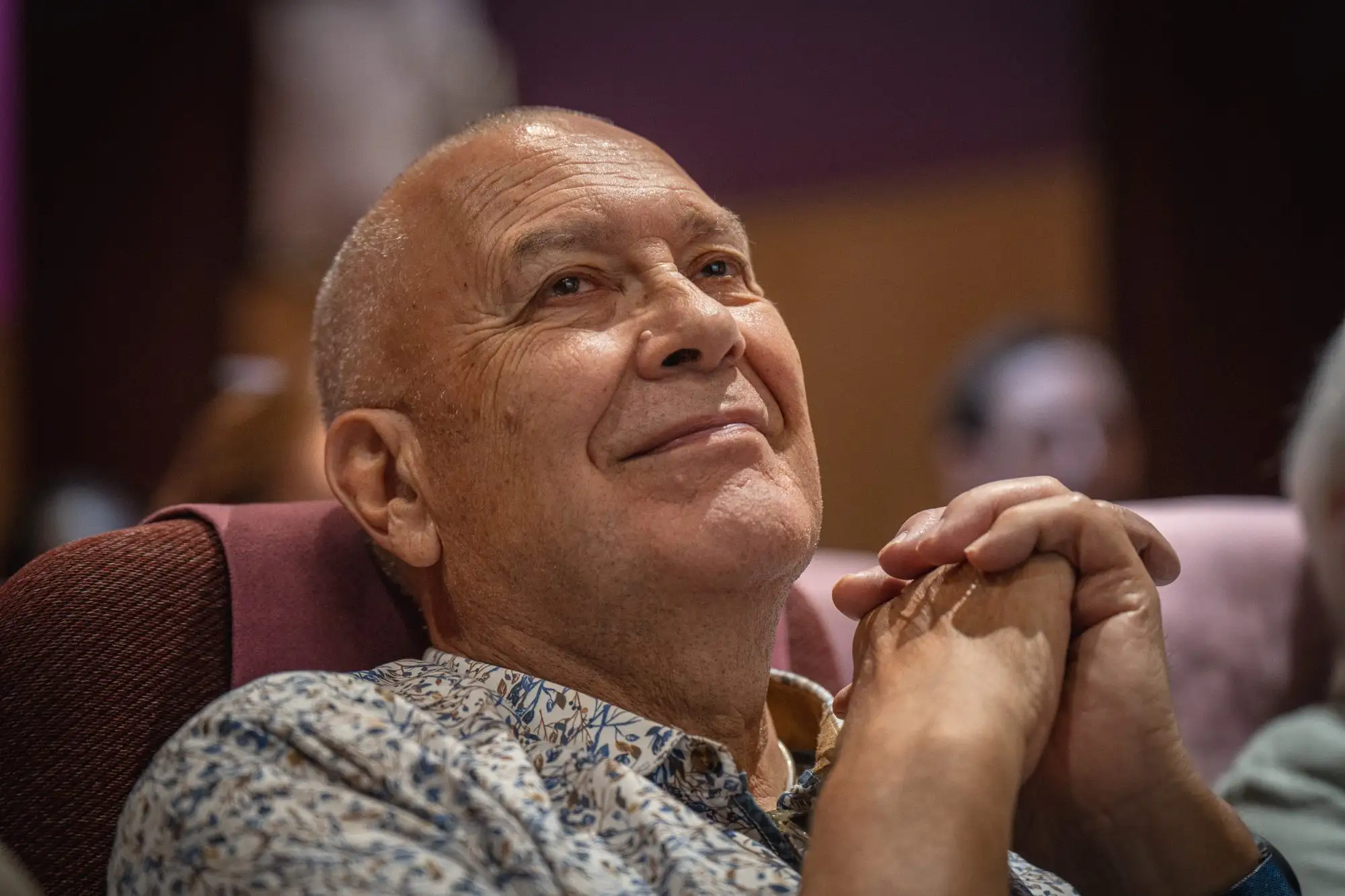 Participant souriant dans la salle du colloque